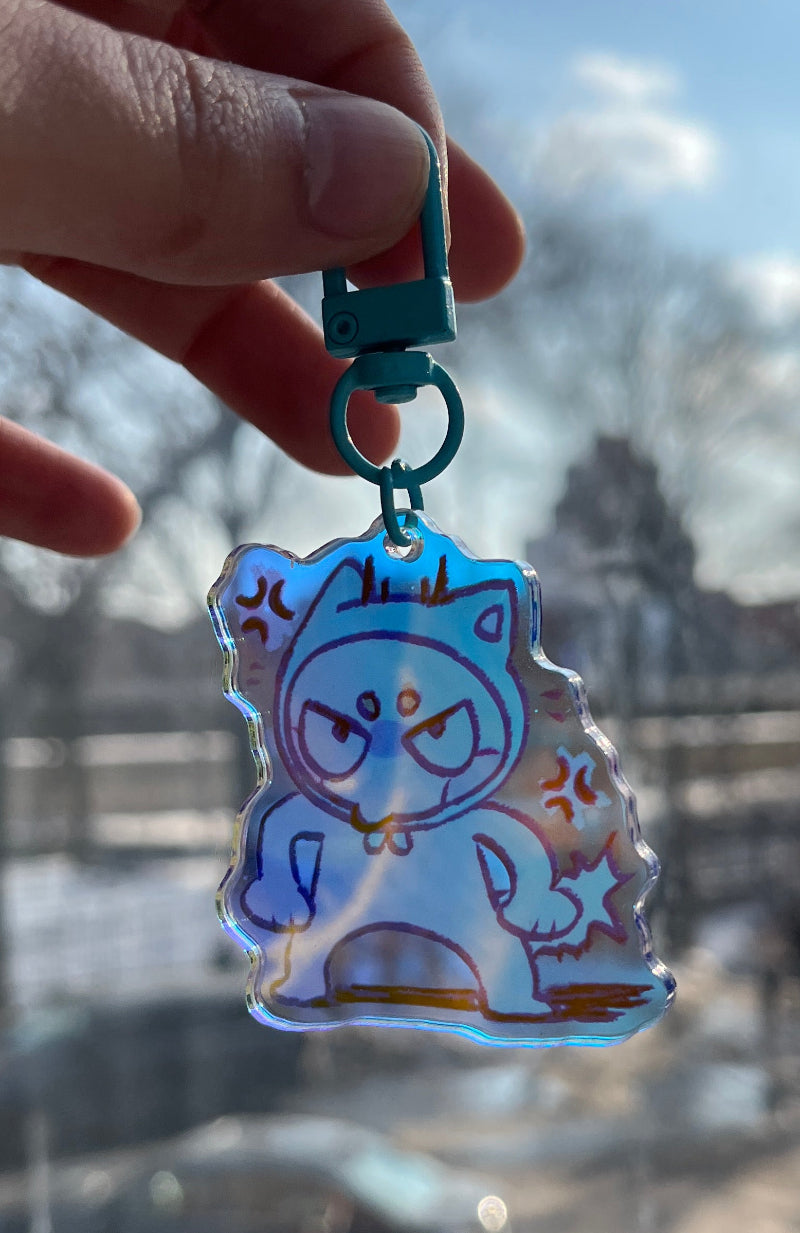 Hand holding a colorful keychain with a blurred background of a tower