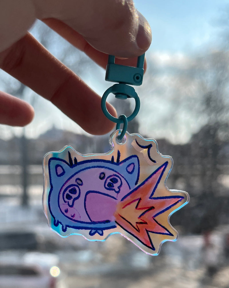 Cat keychain suffering from spiciness against city background