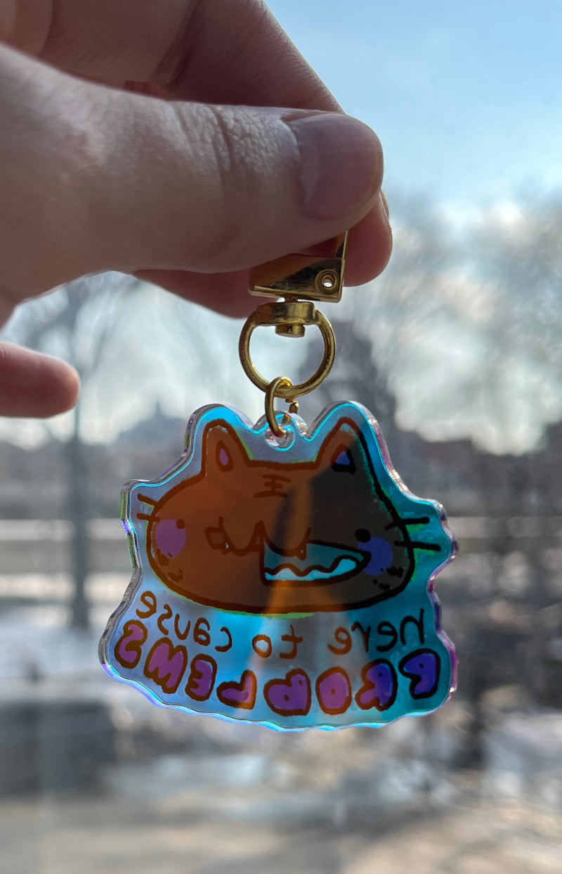 Hand holding a colorful keychain with a cartoon character against a cityscape background