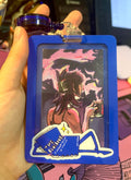 Card with artistic design of a person wearing a mask and holding a drink, framed by a blue border.