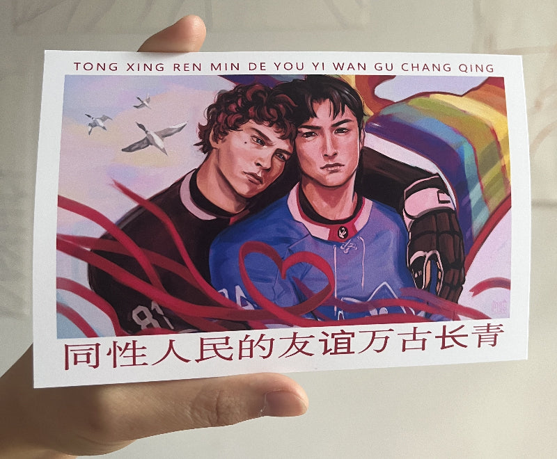 Postcard with two people and rainbow colors held by a hand against a neutral background