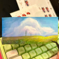 Card with a scenic design held over a green keyboard