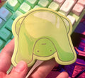 Hand holding a green sticky note pad over a colorful keyboard and mouse pad.